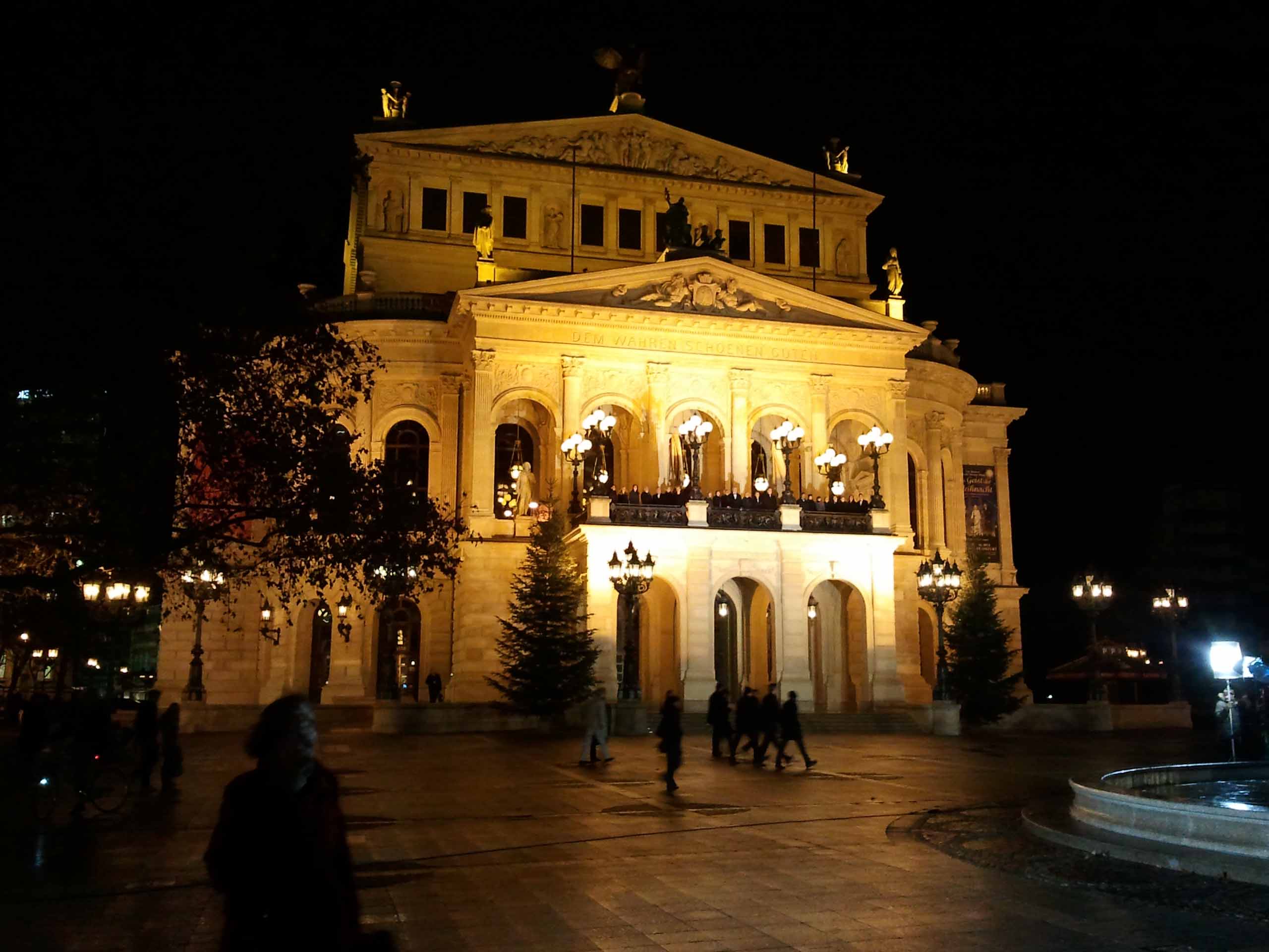 Alte Oper in Frankfurt am Main bei Nacht - kurz vor heilig Abend mit festlicher Beleuchtung und Weihnachtschor.