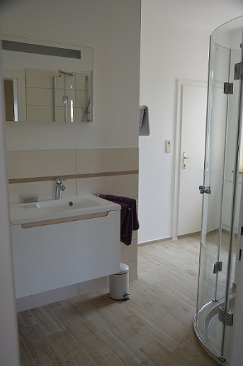 Modernes, geräumiges Badezimmer mit Waschtisch, Schrank und Dusche