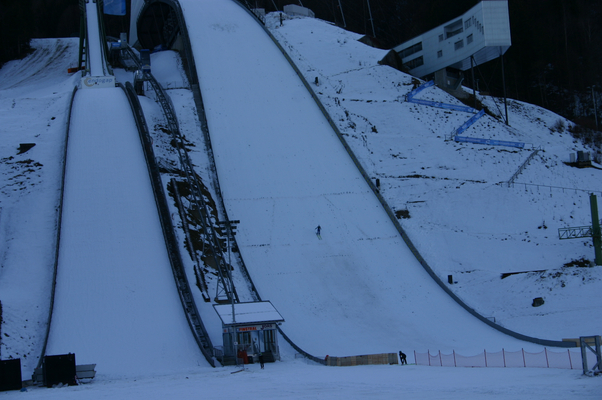 Große Olympiaschanze Garmisch-Partenkirchen mit Springer beim aufsetzten.