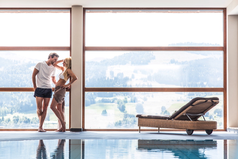 Innenpool mit Panoramablick des Bergkristall – Natur und Spa Hotel Oberstaufen.
