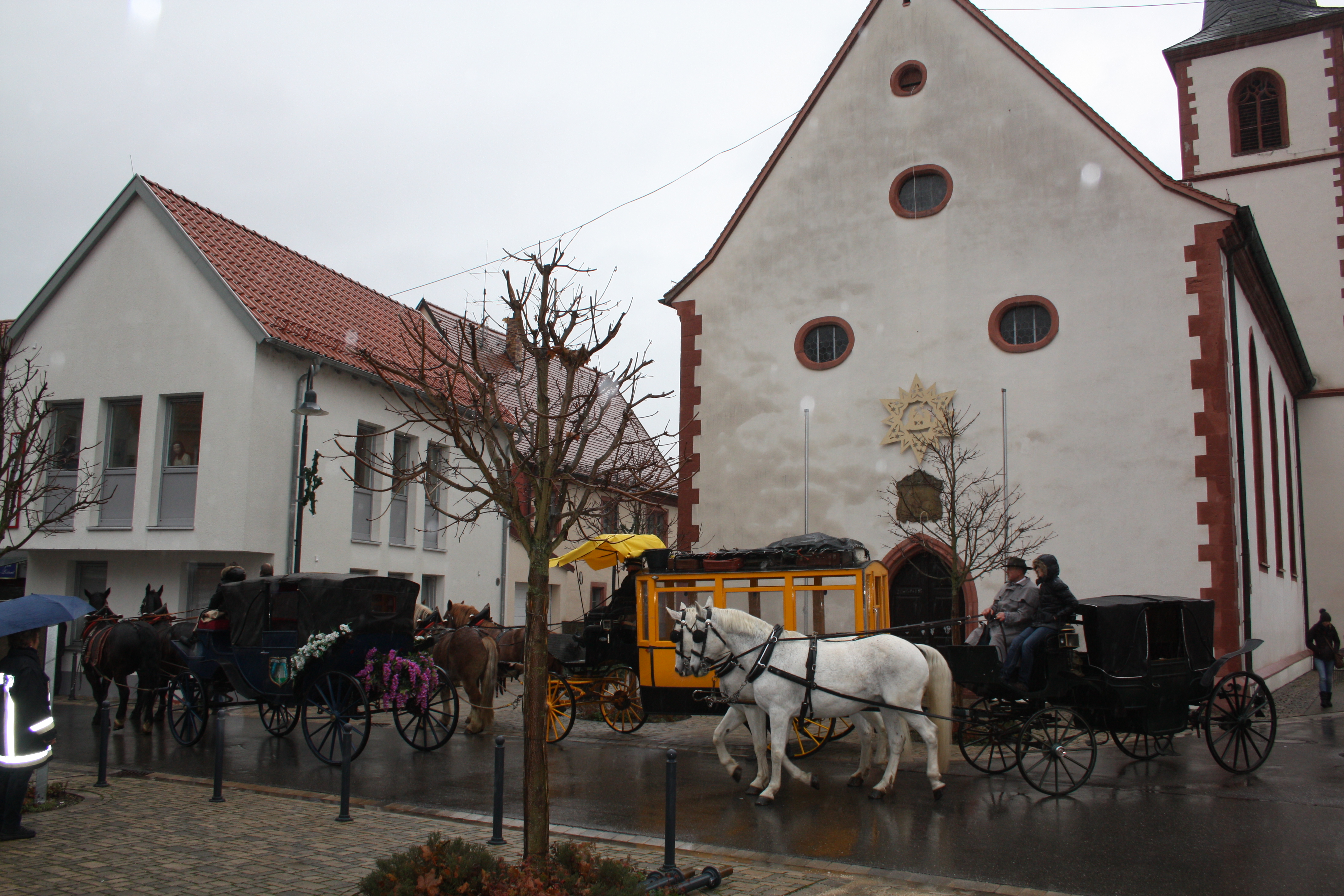 Weihnachtsmarkt Himmelstadt: Die Kutschen fahren vor zum Weihnachtspostamt, vorbei an der Kirche.