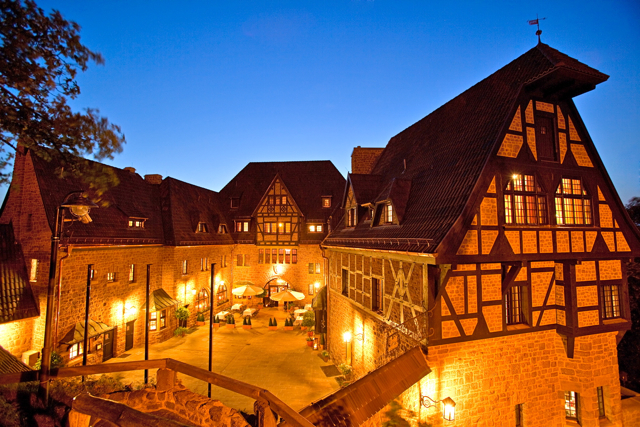 Außenansicht des Hotel auf der Wartburg bei Abenddämmerung.
