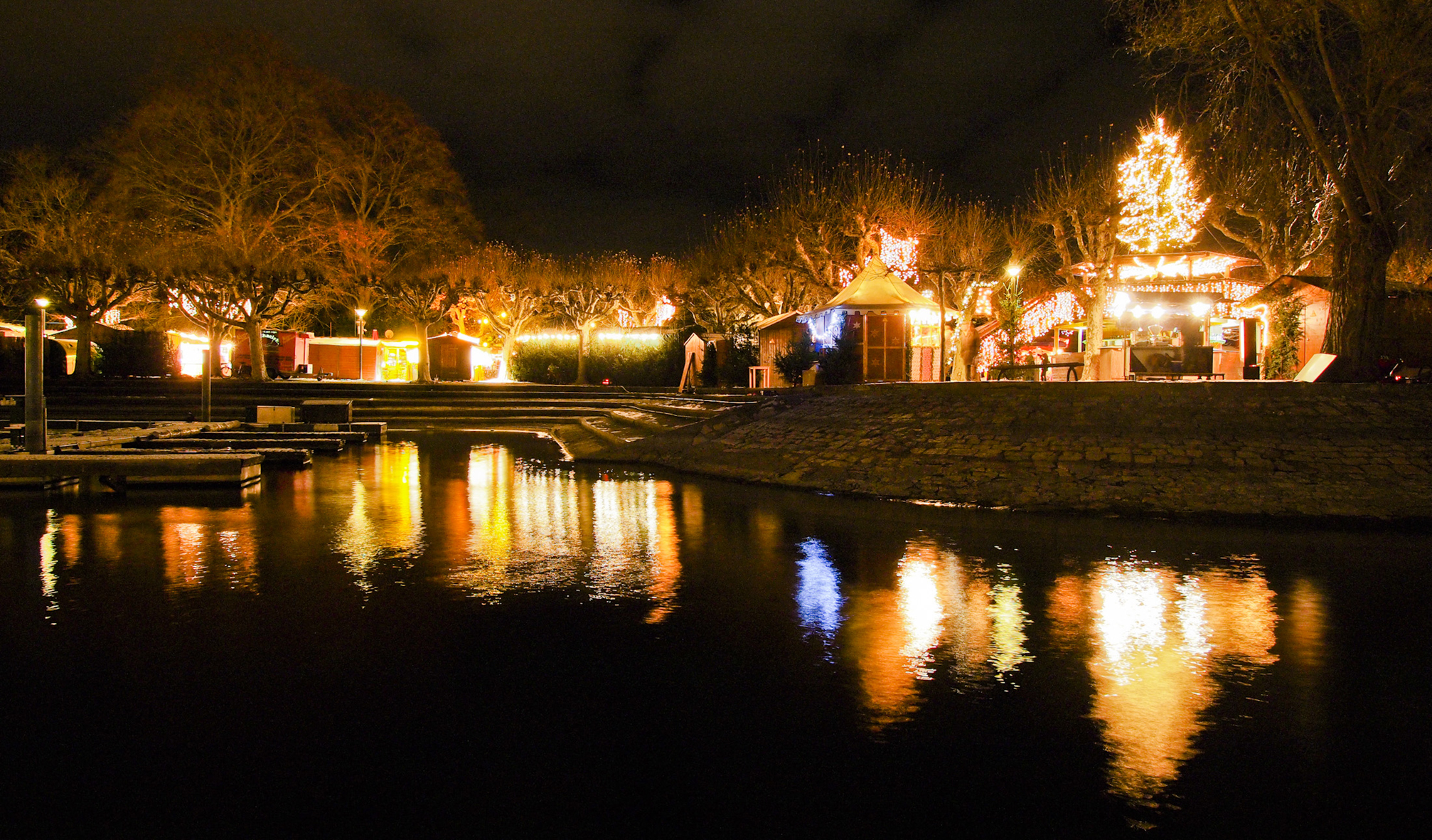 Weihnachtliche Buden spiegeln sich im Bodensee...
