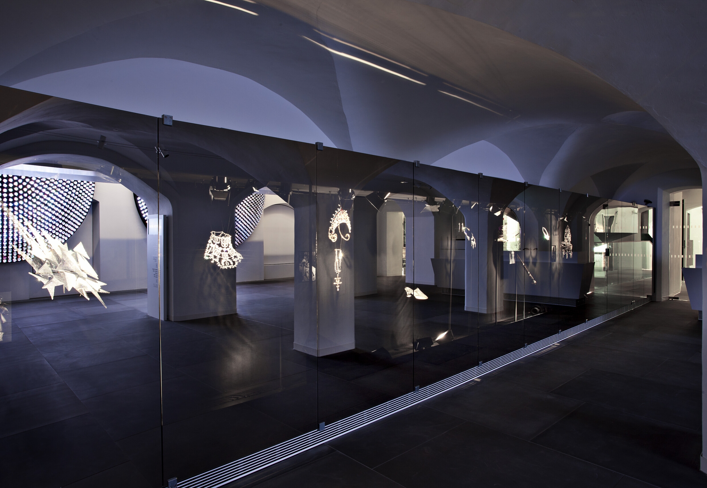 Im Inneren der eindrucksvollen Spiegelwand im Eingangsbereich des Swarovski Innsbruck verbergen sich faszinierende Kristallkreationen und legendäre Stücke, darunter aufwändige Signature Pieces für die Königinnen des Films und der Bühne.