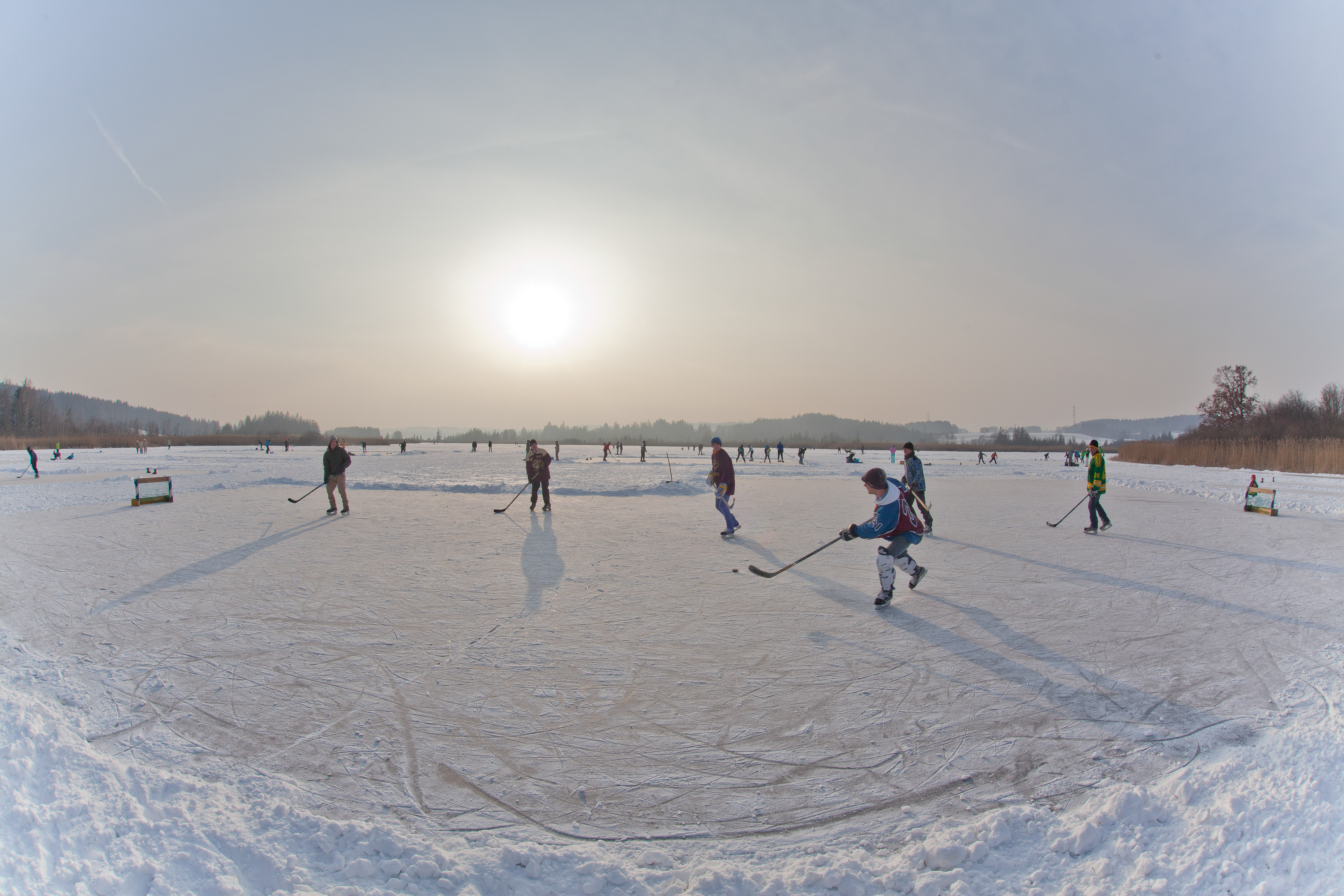 Maisinger See im Winter mit Eishockey-Spielern.
