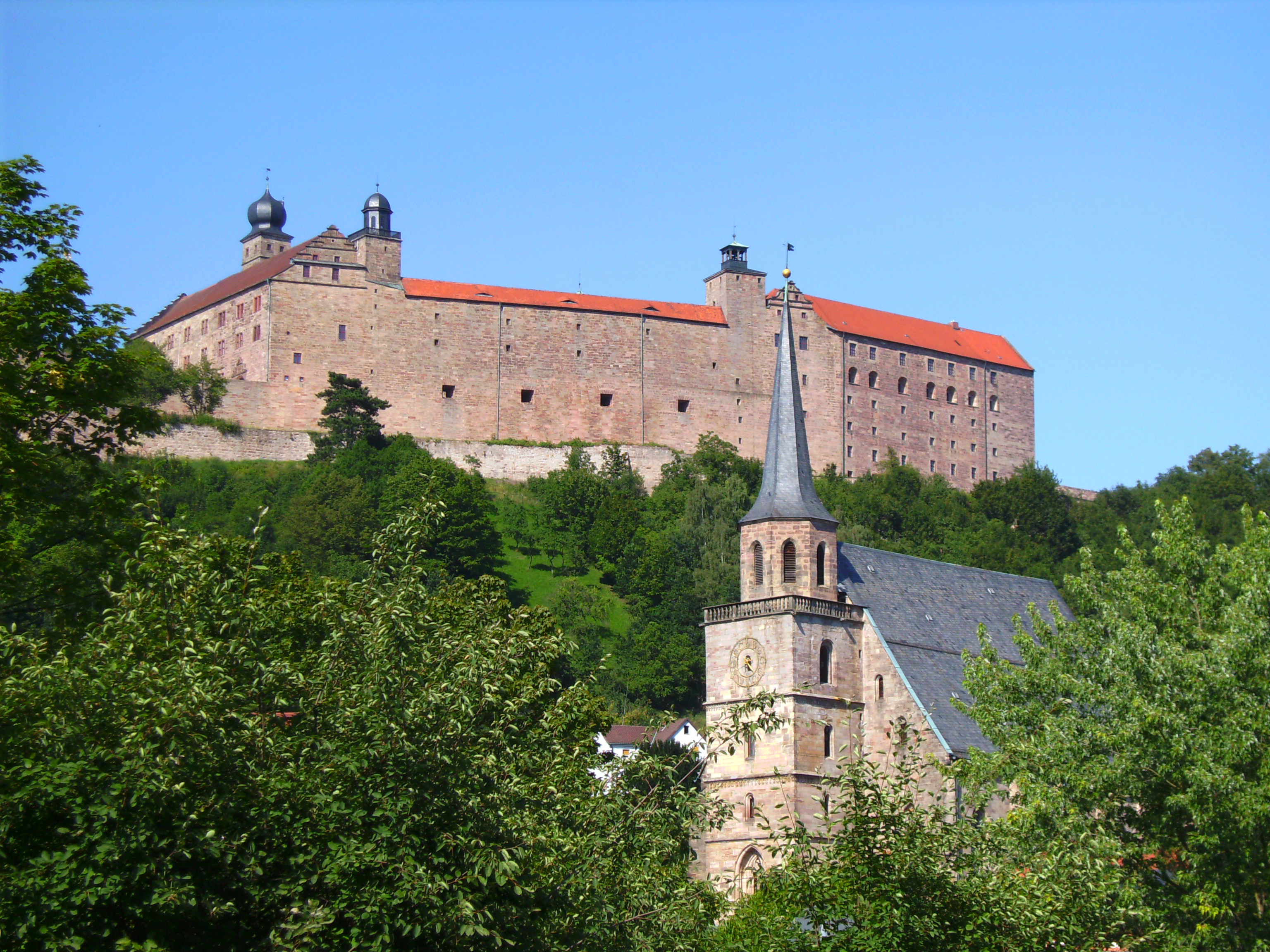 Die Plassenburg, Wahrzeichen der Stadt Kulmbach, und die spätgotische Kirche St. Petri.
