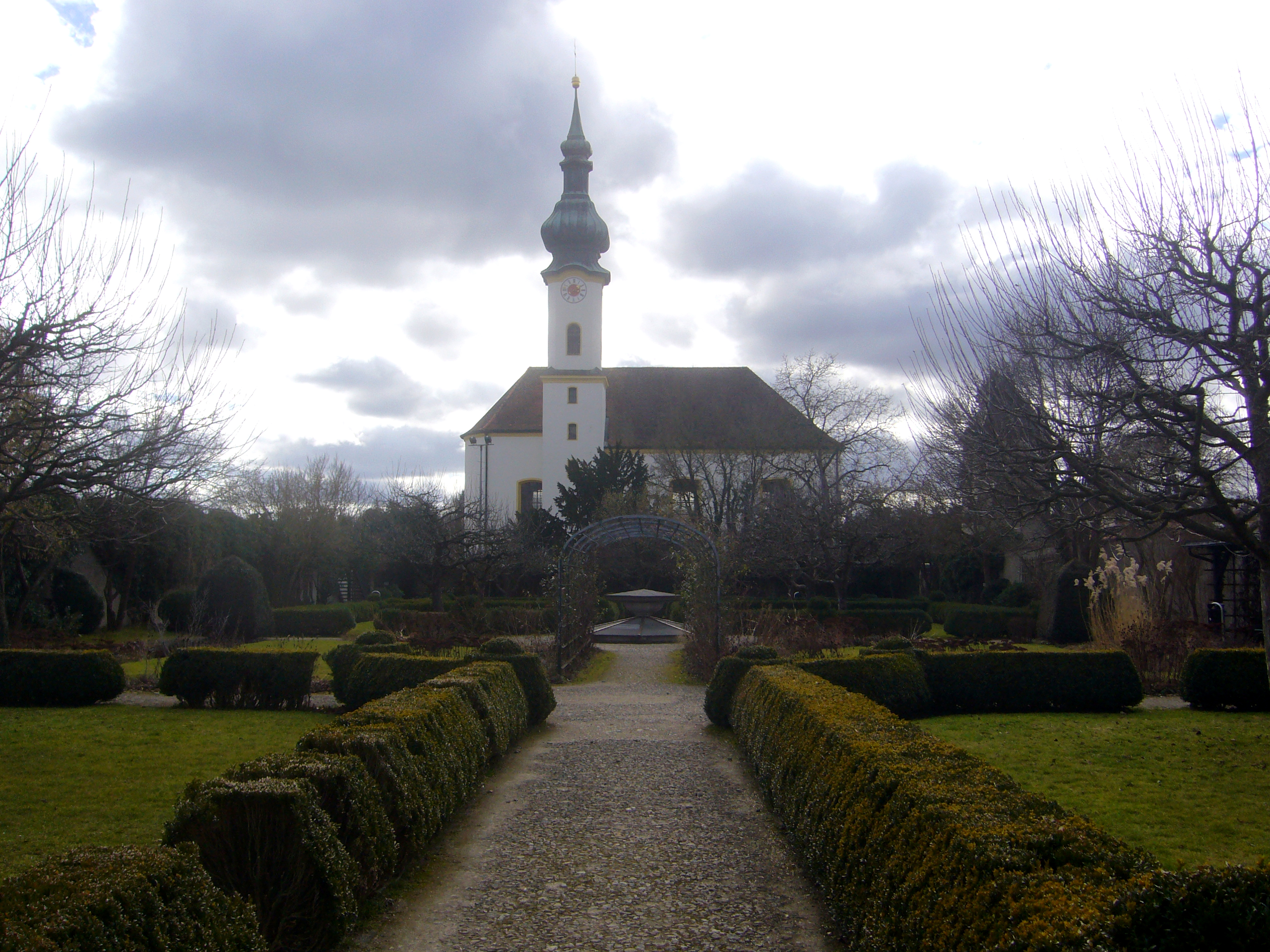 Die Rokokokirche St. Joseph mit dem Starnberger Schlossgarten.
