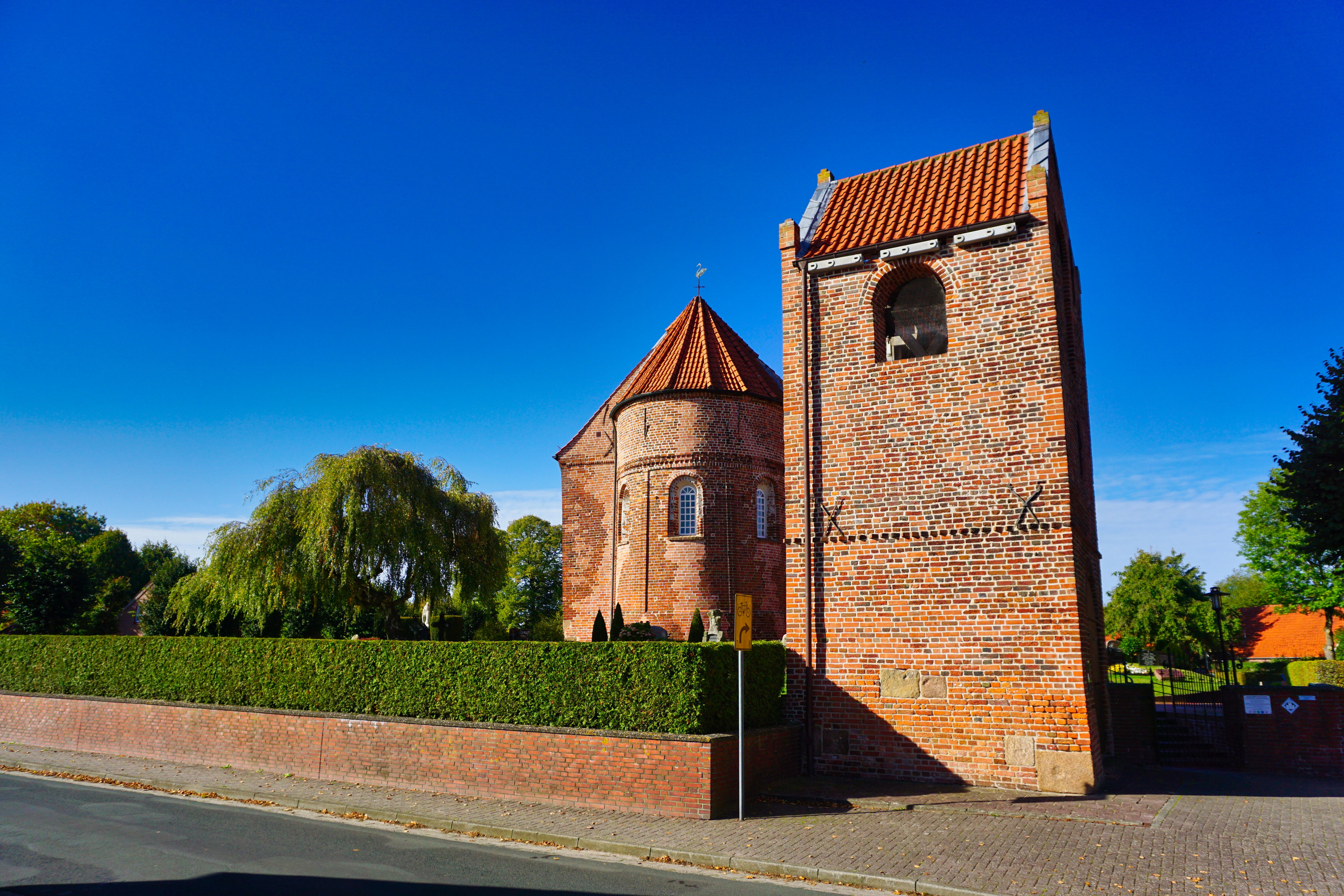 Die St. Mauritius-Kirche mit dem freistehenden Glockenturm in Horsten, Friedeburg.