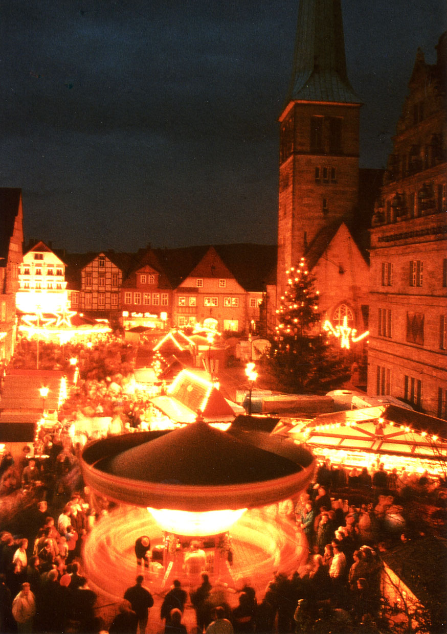 Der Weihnachtsmarkt in Hameln hell beleuchtet durch Weihnachtsschmuck und leuchtende Stände.